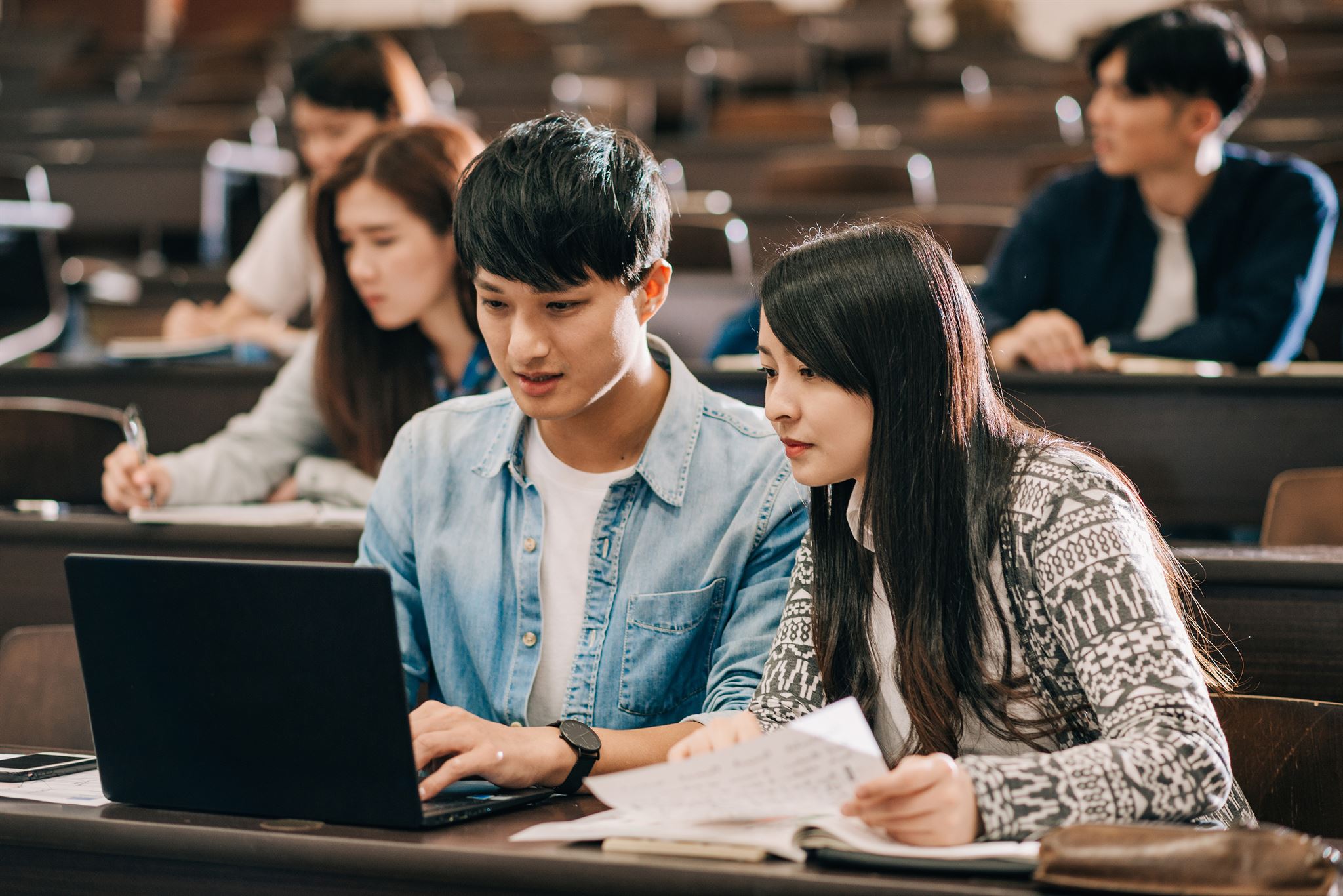 People-seated-on-tiered-chairs-in-lecture-hall